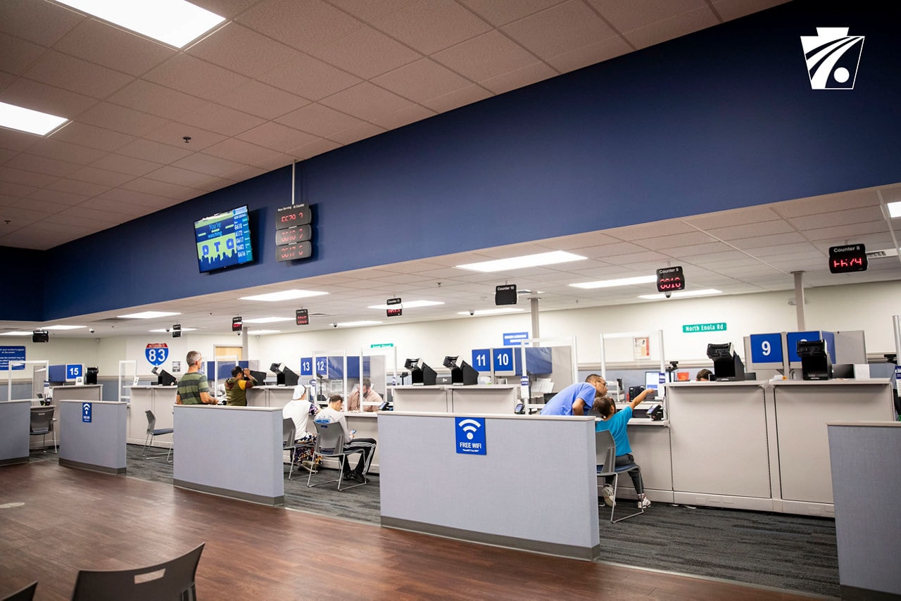 DMV title office interior with numbered service windows and queue management system
