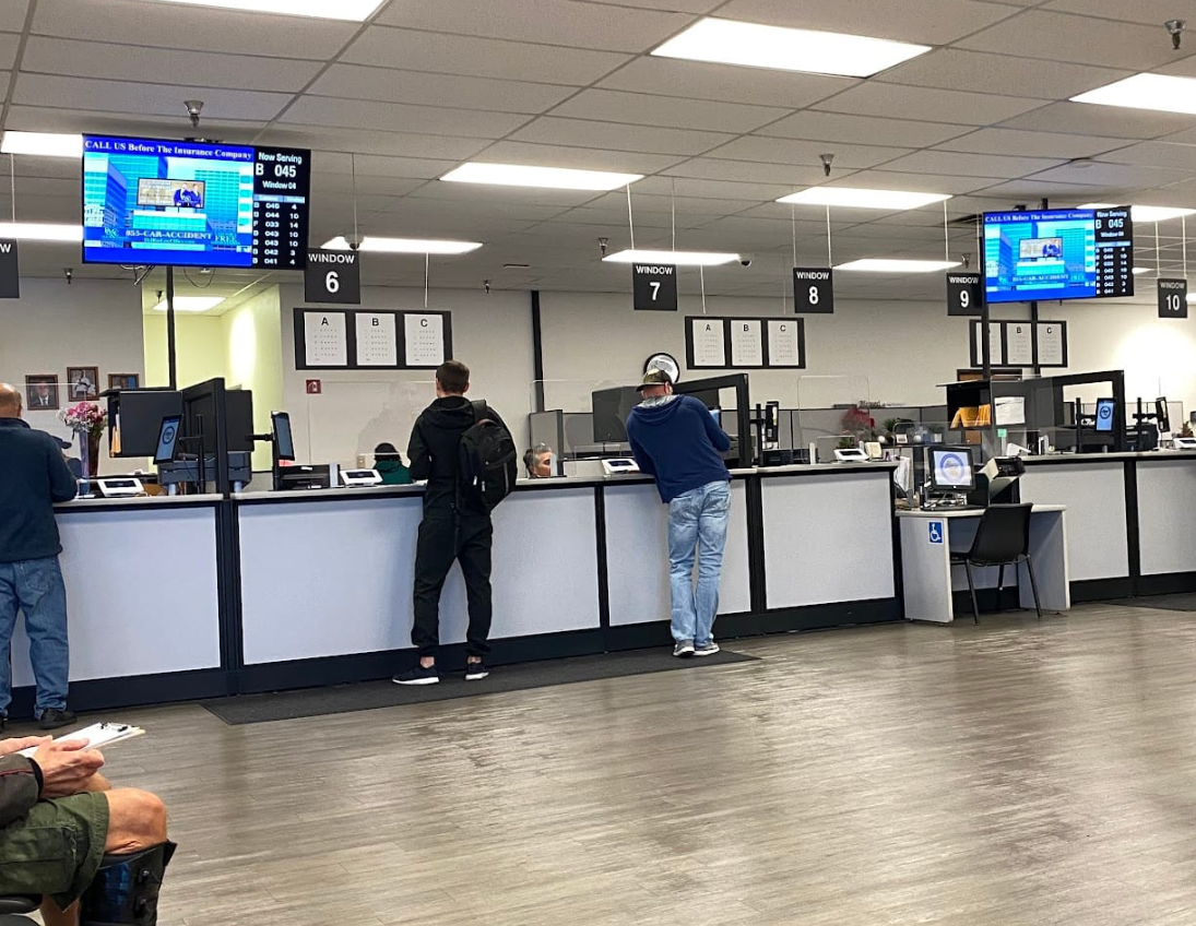 DMV service windows with customers completing title and registration transactions