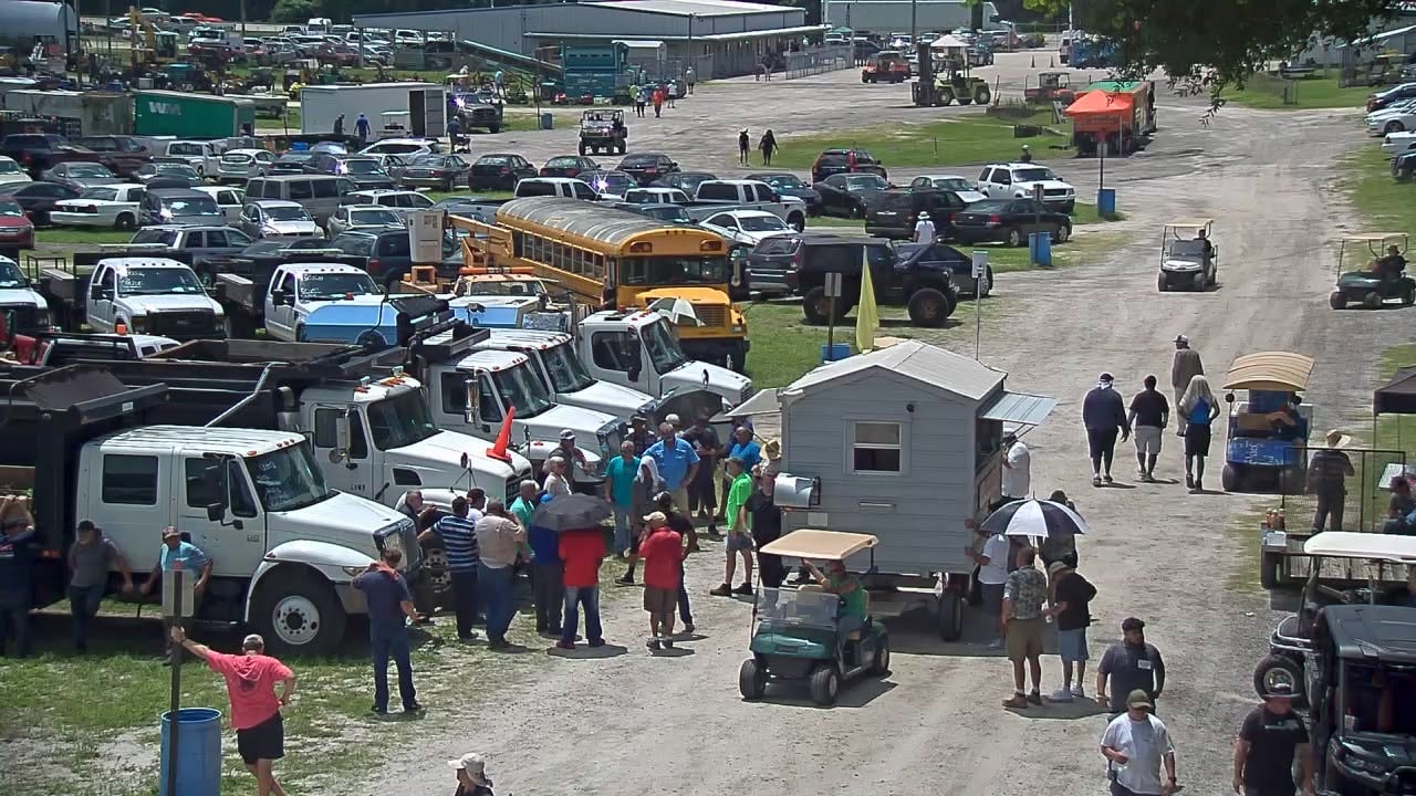 Buyers walking through trucks and heavy equipment at Tampa Machinery Works