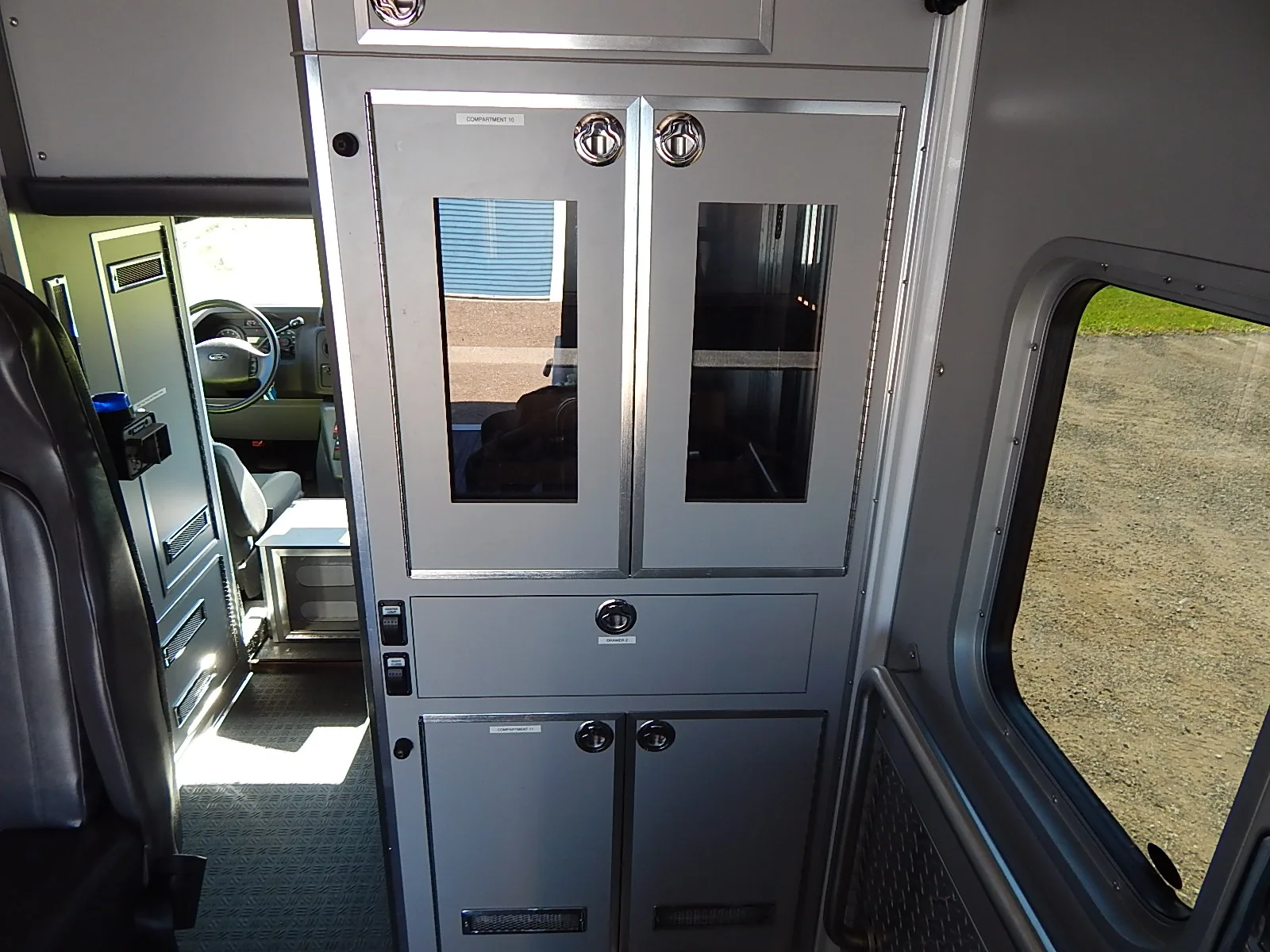 The patient compartment of the Wisconsin ambulance, with its workstation, outlets, cabinets and drawers.