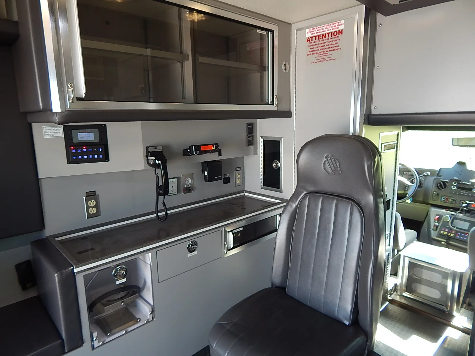The patient compartment of the Wisconsin ambulance, with its workstation, outlets, cabinets and drawers.