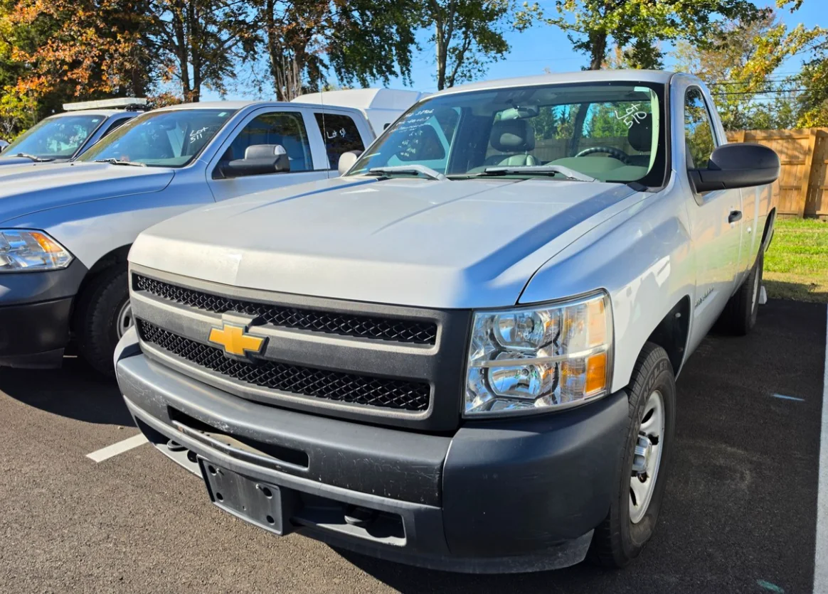 A silver Chevrolet Silverado regular cab work truck in the Delaware Surplus Services yard.