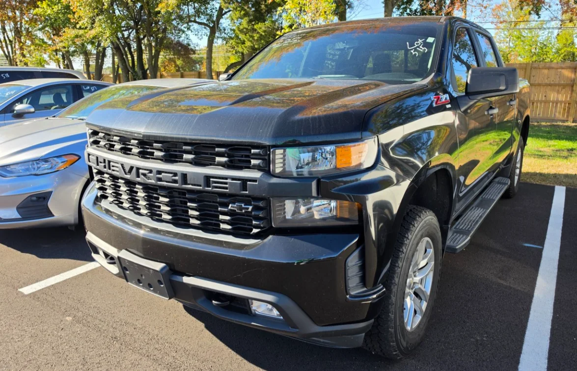 A black Chevrolet Silverado Z71 crew cab pickup in the Delaware Surplus Services yard.