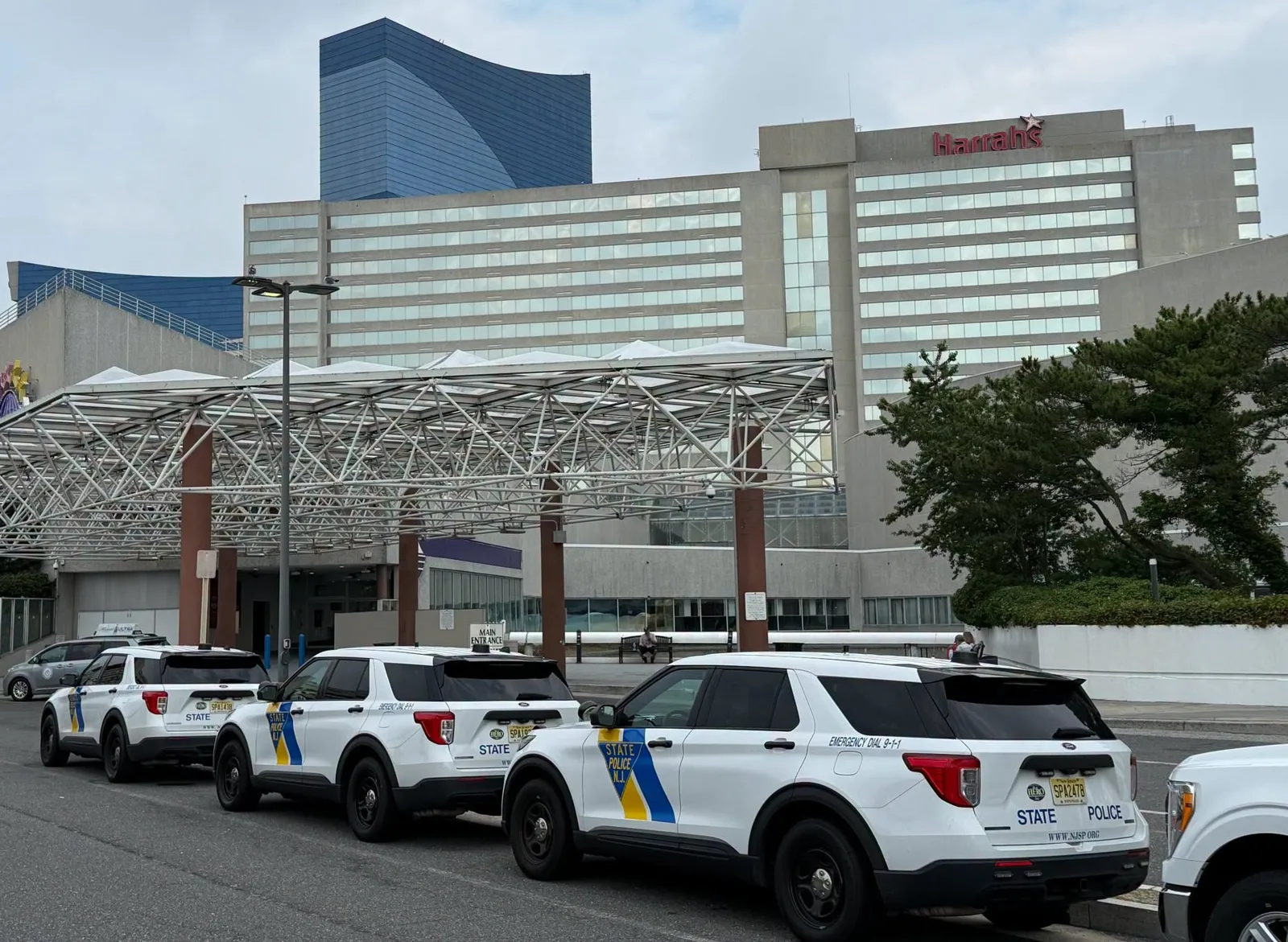 Three white New Jersey State Police Ford Explorer Police Interceptor Utilities parked in a row outside a casino entrance in Atlantic City.