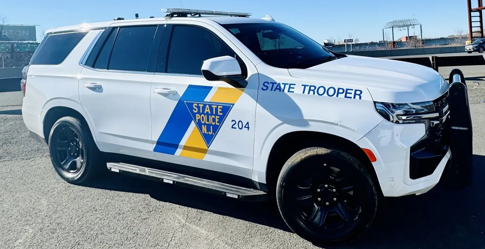 A white New Jersey State Police Chevrolet Tahoe, unit 204, side view with light bar and push bumper.