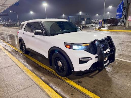 White Ford Explorer Police Interceptor parked at night under overhead lighting