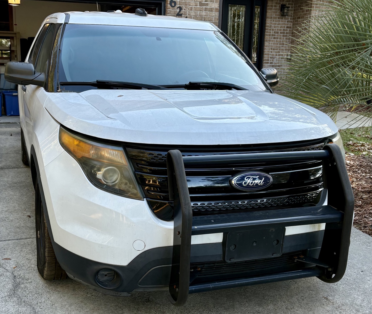White Ford Explorer Police Interceptor parked in a driveway, front three-quarter view