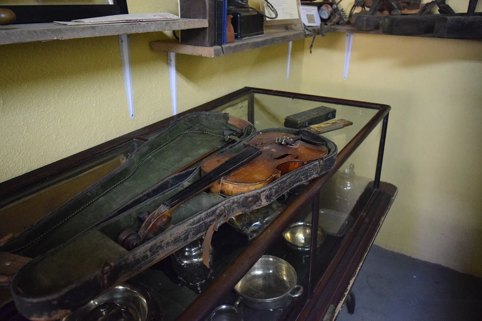 Antique wheelchairs, a violin, a harmonica, a convex mirror and other pieces from the asylum's collection.